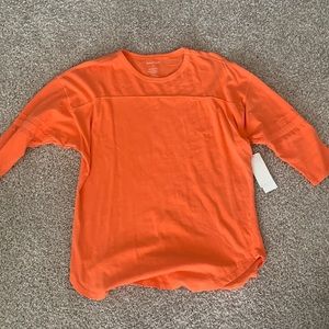 Orange sports style quarter length sleeve shirt